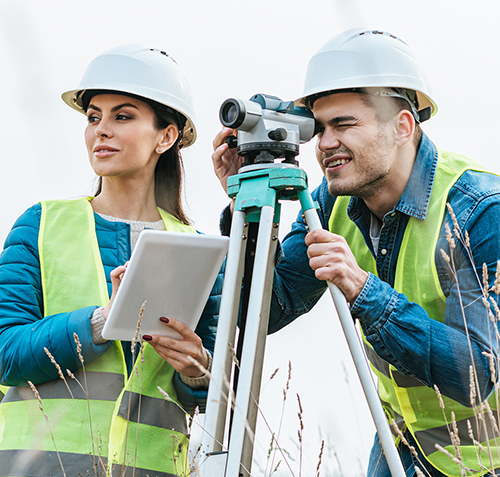 Surveyors working with digital level and using tablet in field