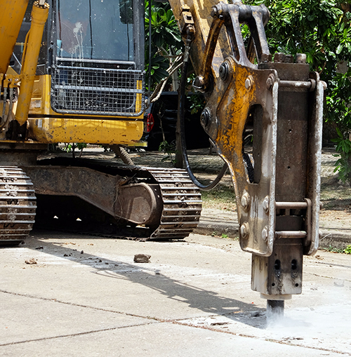 Road drilling vehicle, backhoe, yellow, attached to the drilling